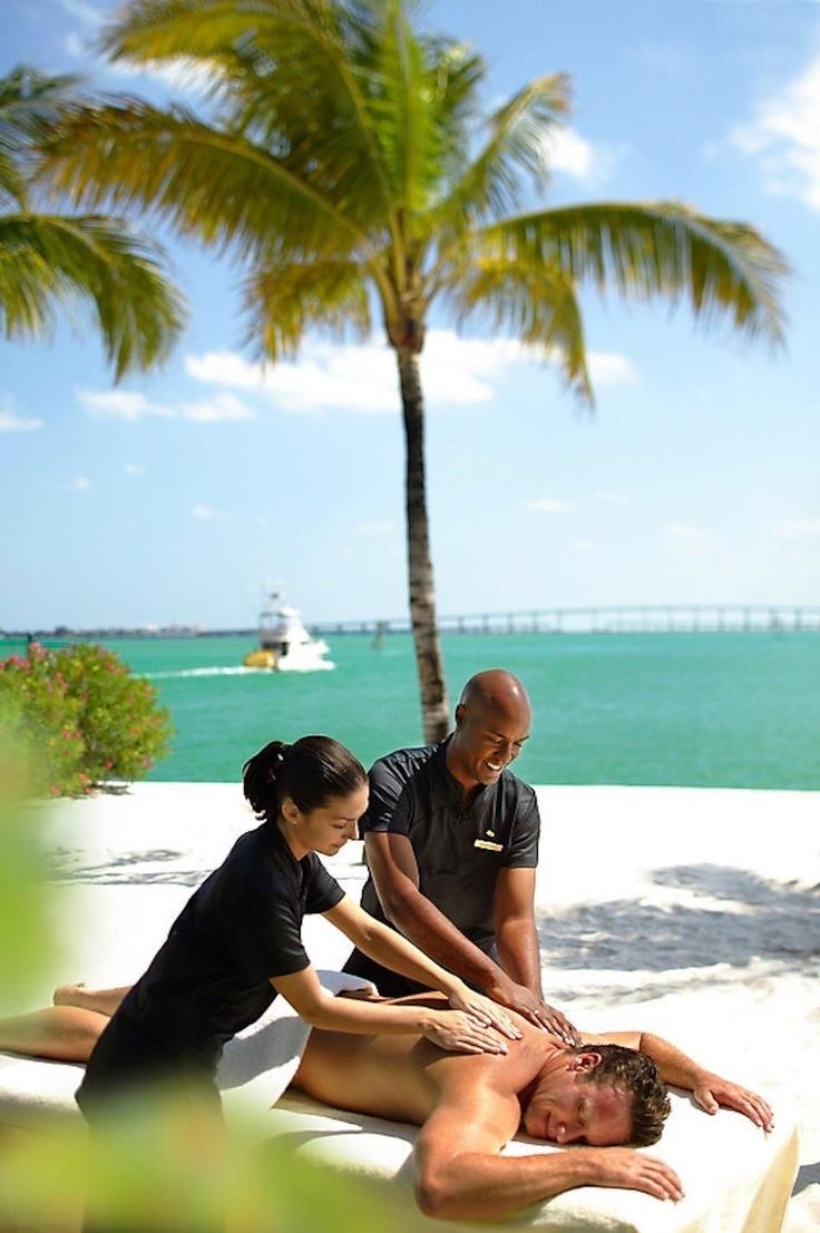 Four-hand massage session by the water